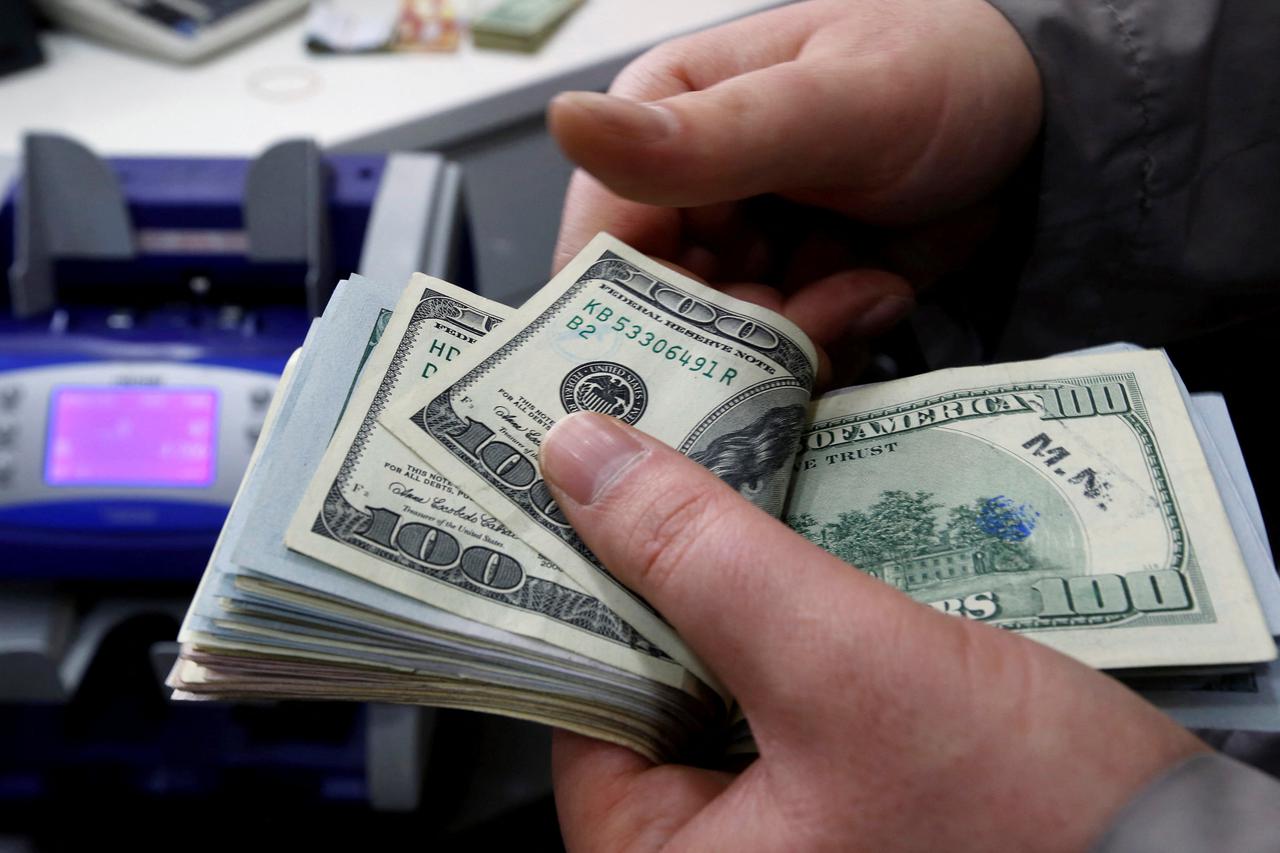 FILE PHOTO: A money changer counts U.S. dollar bills at a currency exchange office in central Istanbul