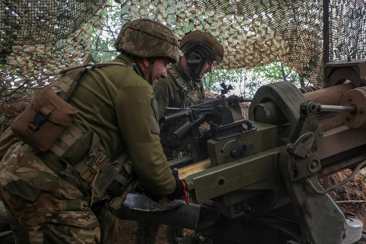 FILE PHOTO: Ukrainian service members fire a L119 howitzer in Donetsk region