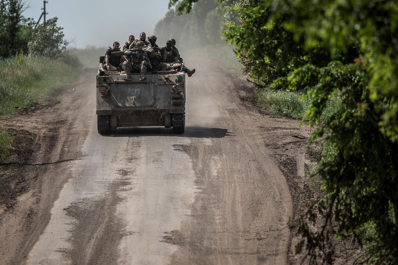 Ukrainian service members ride a M113 armoured personnel carrier near the front line city of Bakhmut