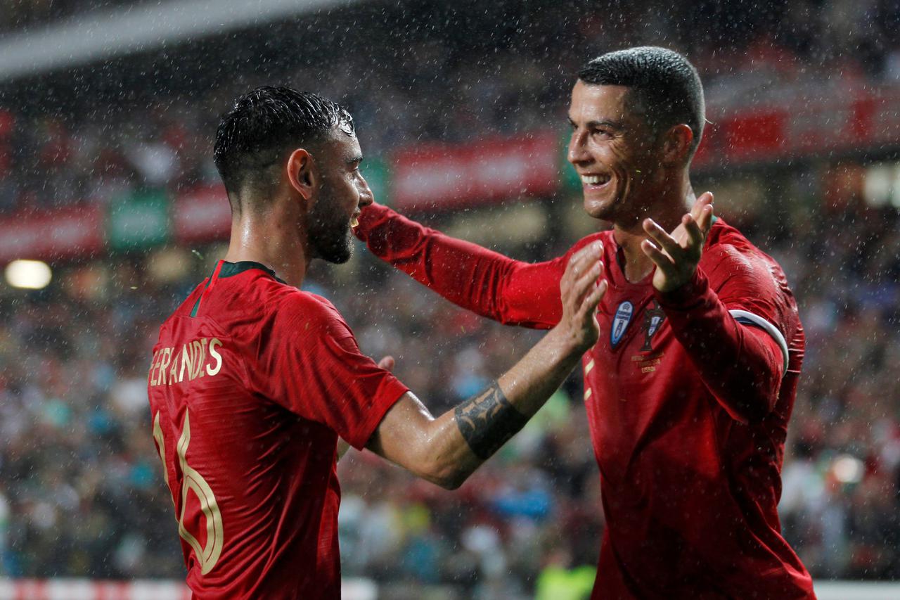 FILE PHOTO: Portugal's Bruno Fernandes celebrates with skipper Cristiano Ronaldo after scoring their second goal in a 3-0 win over Algeria at the Estadio da Luz in Lisbon, Portugal