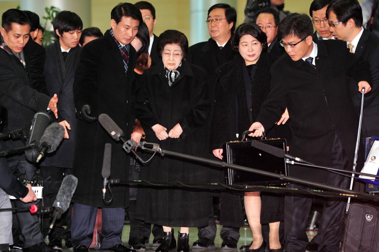 \'Lee Hee-Ho (C), widow of former South Korean president Kim Dae-Jung, and Hyundai Group chairwoman Hyun Jeong-Eun (2nd R) are surrounded by microphones of members of the press as they leave for North