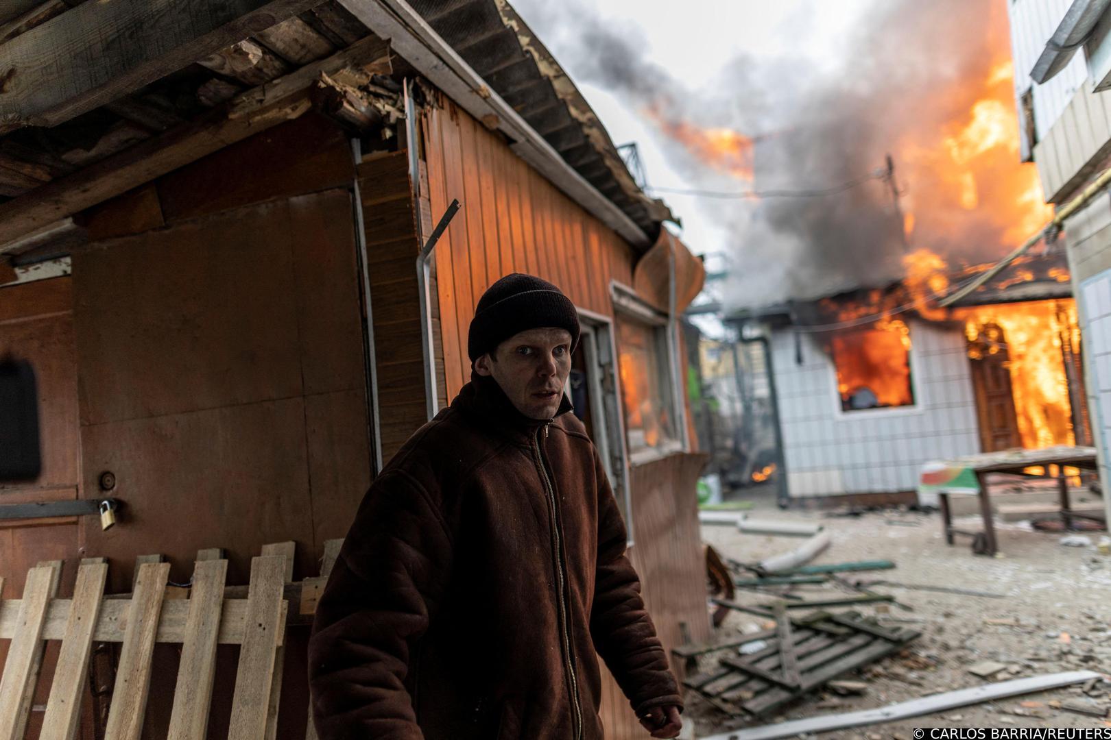 A local resident reacts as a house is on fire after heavy shelling on the only escape route used by locals to leave the town of Irpin, while Russian troops advance towards the capital, 24km from Kyiv, Ukraine March 6, 2022. REUTERS/Carlos Barria Photo: CARLOS BARRIA/REUTERS