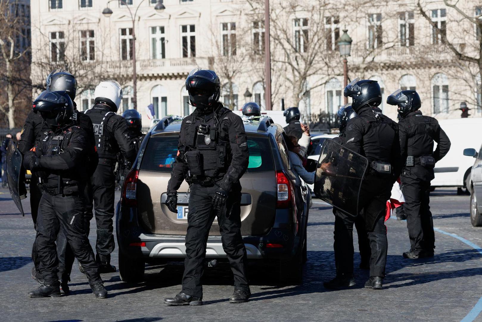 Police officers check a car owner on the Champs-Elysees avenue as cars parade during their "Convoi de la liberte" (The Freedom Convoy), a vehicular convoy to protest coronavirus disease (COVID-19) vaccine and restrictions, in Paris, France, February 12, 2022. REUTERS/Benoit Tessier Photo: BENOIT TESSIER/REUTERS