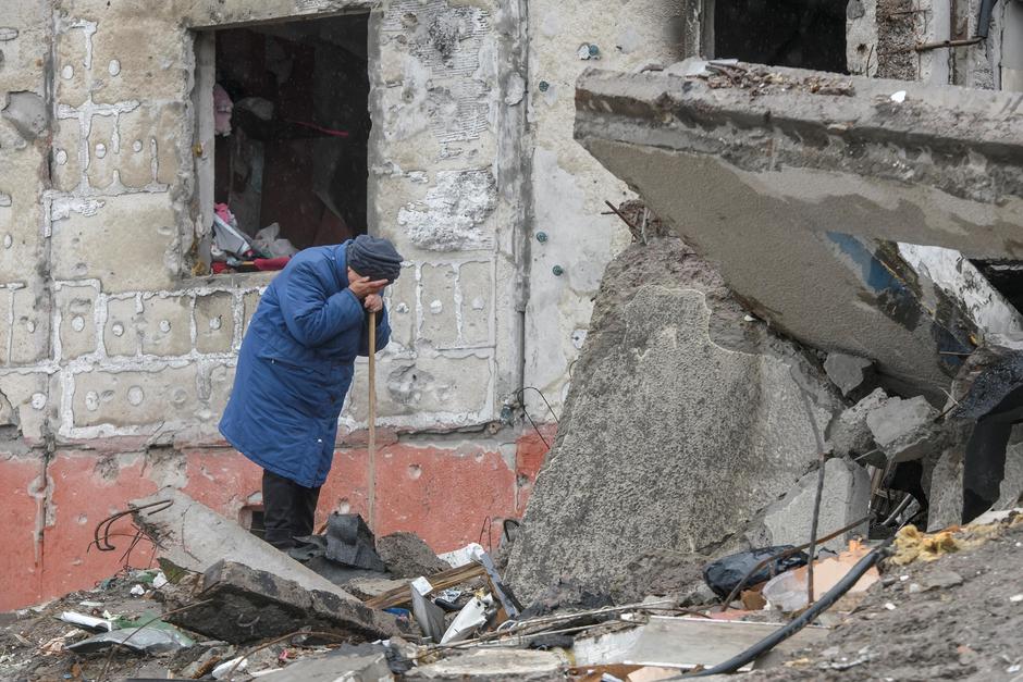 A woman cries as she tries to find a body of her son among debris of a residential destroyed during Russia’s invasion in the town of Borodianka