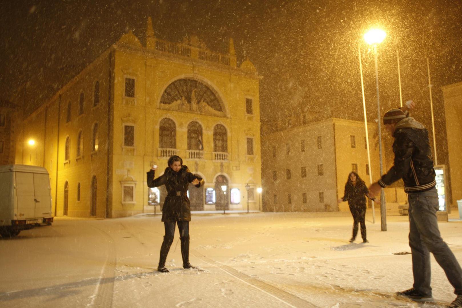 03.02.2012., Split - Grad se probudio pod bijelim pokrivacem i na -4 stupnja sto je bilo dovoljno da se proglasni "snjezni dan". Vrtici, skole, kao i institucije imaju opravdanje od gradonacelnika zbog neradnog dana, a gradjanima je savjetovano da ostanu u toplim domovima. Grudanje ispred HNK. rPhoto: Ivo Cagalj/PIXSELL