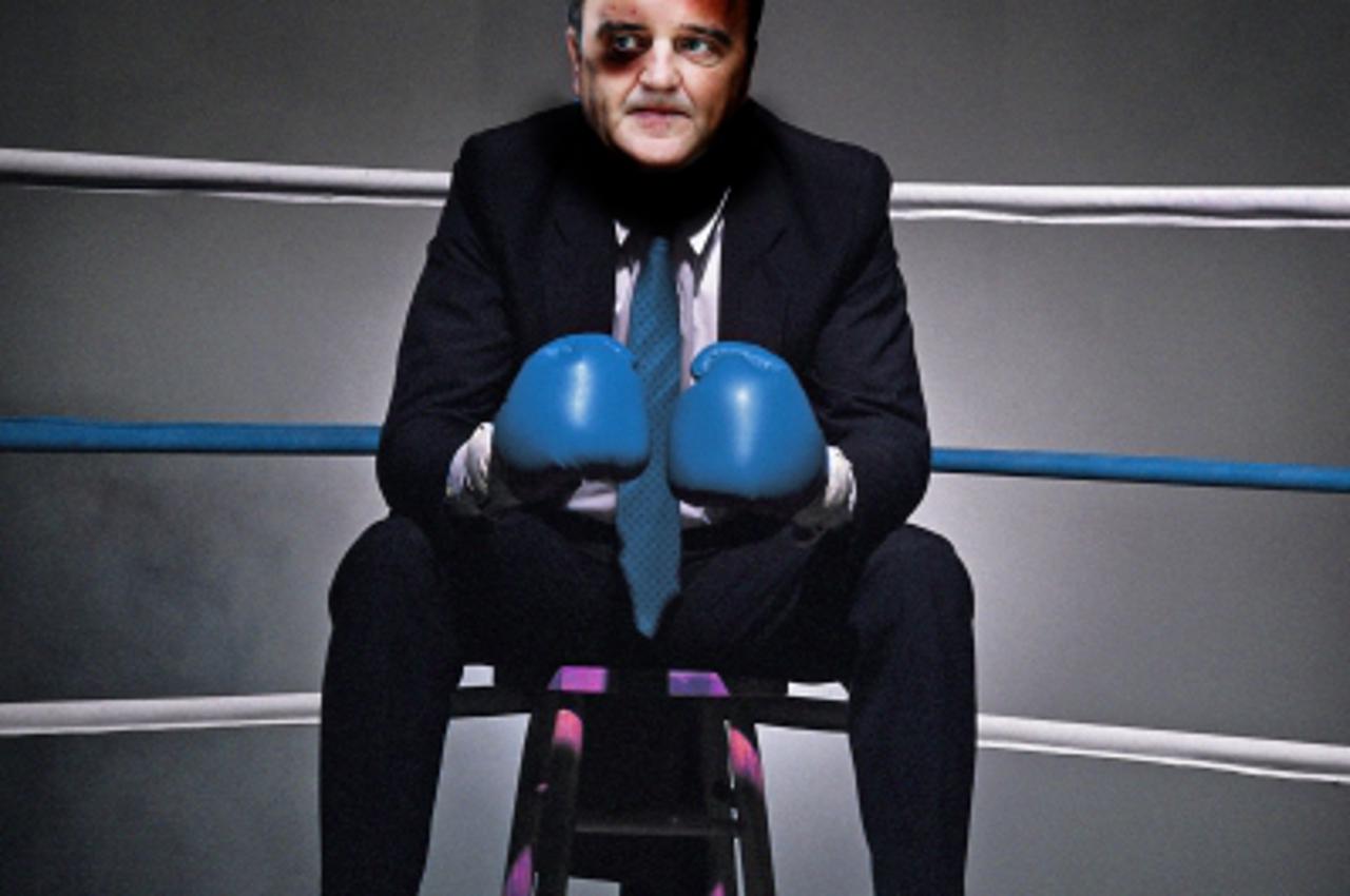 \'Businessman sitting in corner of boxing ring\'