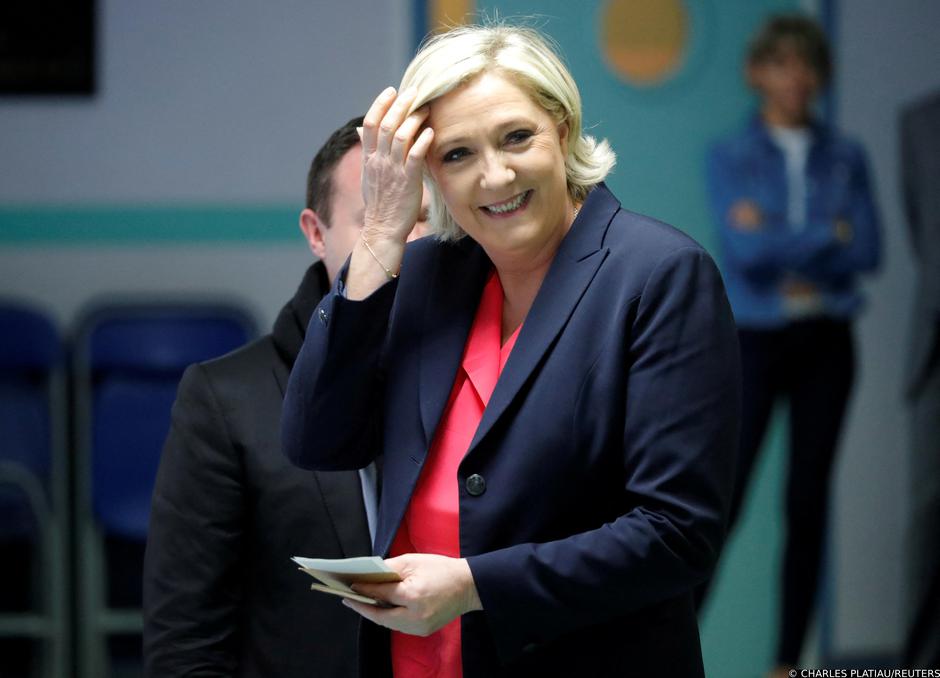 FILE PHOTO: Marine Le Pen, French National Front political party candidate for French 2017 presidential election, smiles before voting in the second round of 2017 French presidential election at a polling station in Henin-Beaumont