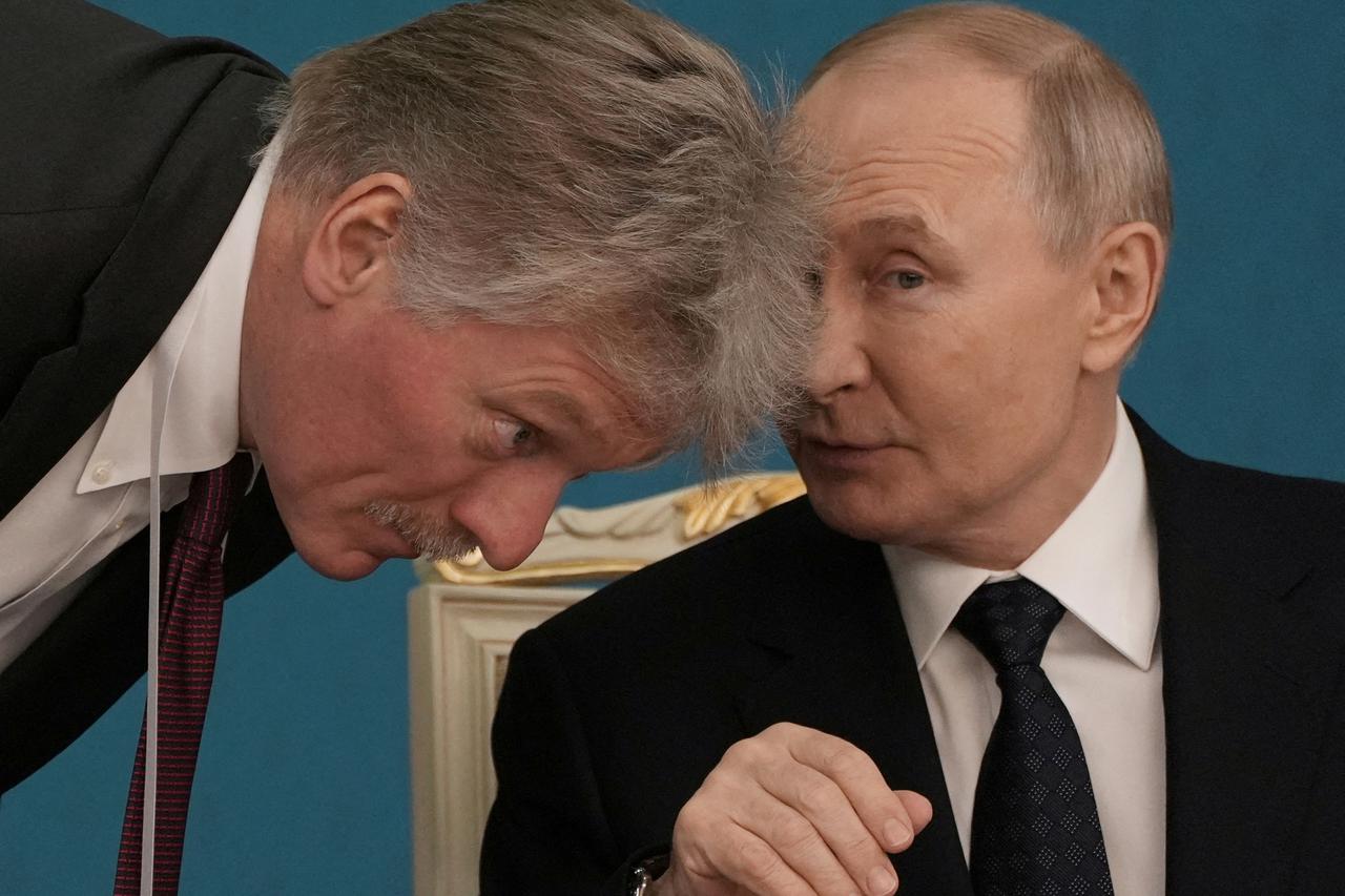 FILE PHOTO: Russian President Vladimir Putin talks to Kremlin spokesman Dmitry Peskov