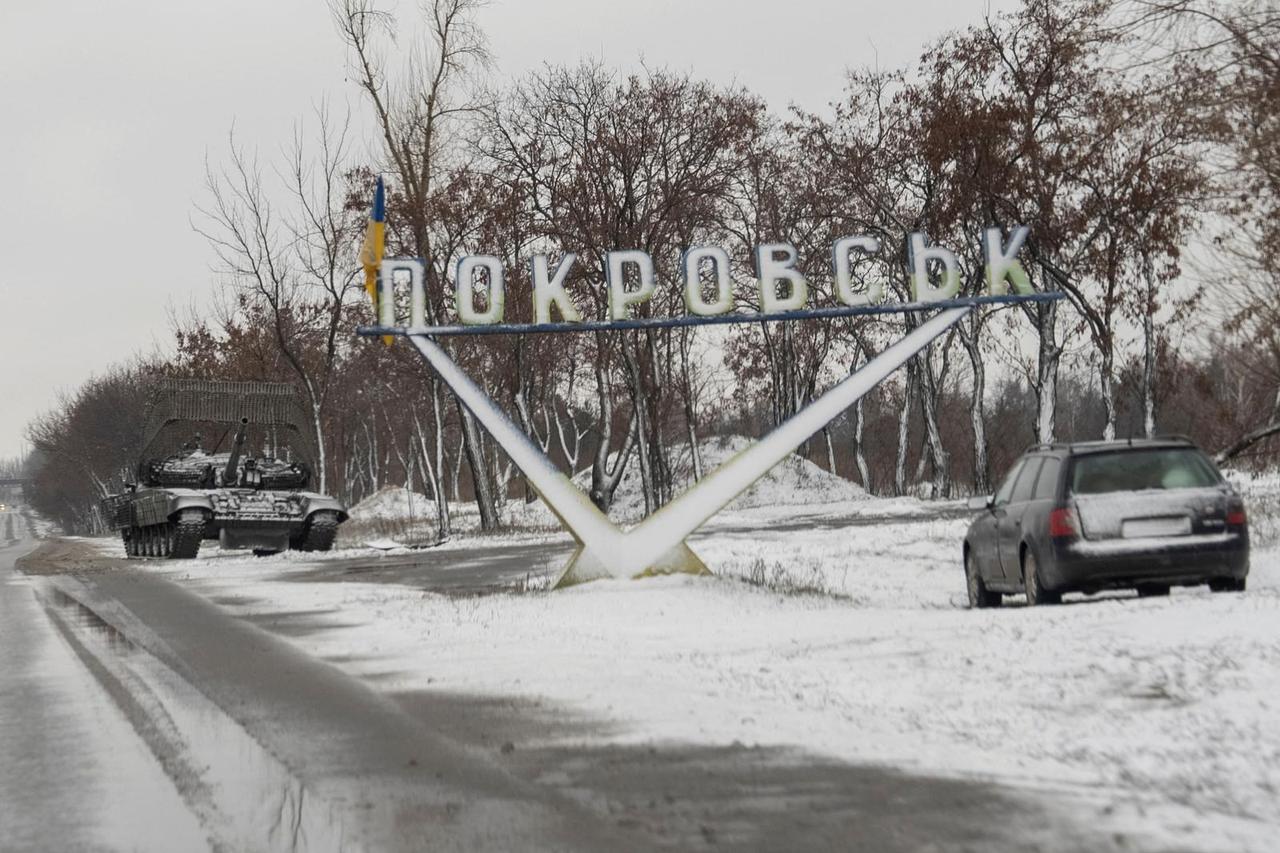 FILE PHOTO: A Ukrainian tank and a car are parked near a road sign that reads, 'Pokrovsk’ in the town of Pokrovsk