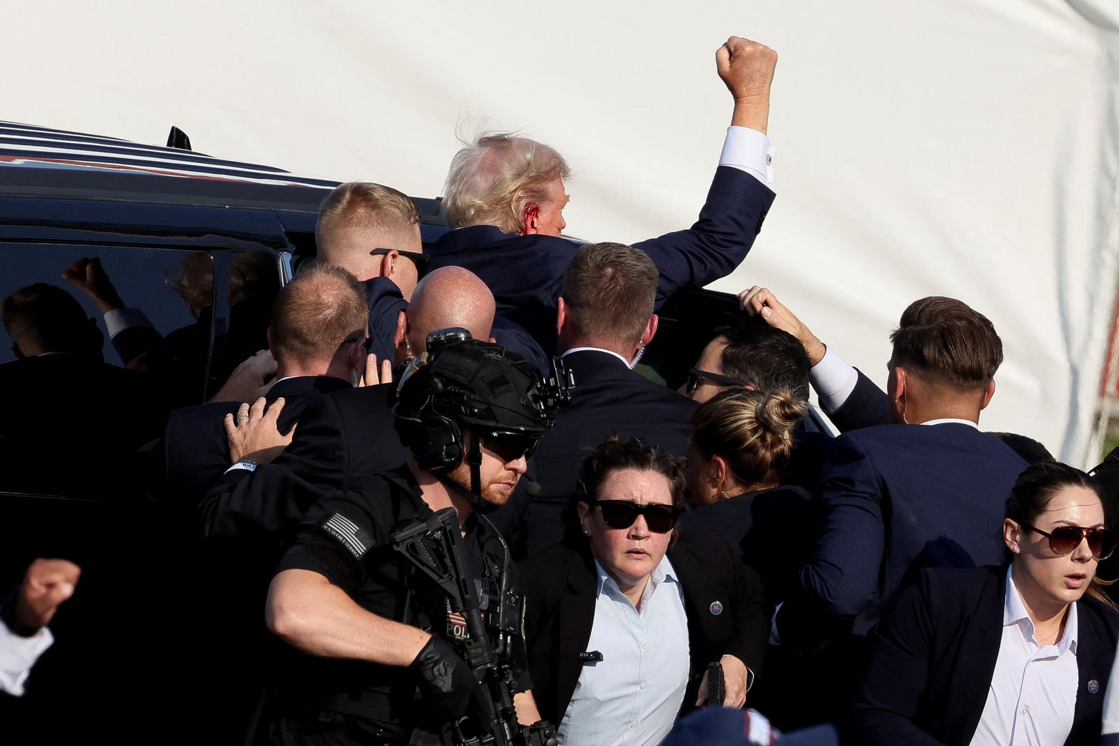 Republican presidential candidate and former U.S. President Donald Trump gestures as he gets into a vehicle with the assistance of U.S. Secret Service personnel after he was shot in the right ear during a campaign rally at the Butler Farm Show in Butler, Pennsylvania, U.S., July 13, 2024. REUTERS/Brendan McDermid Photo: BRENDAN MCDERMID/REUTERS