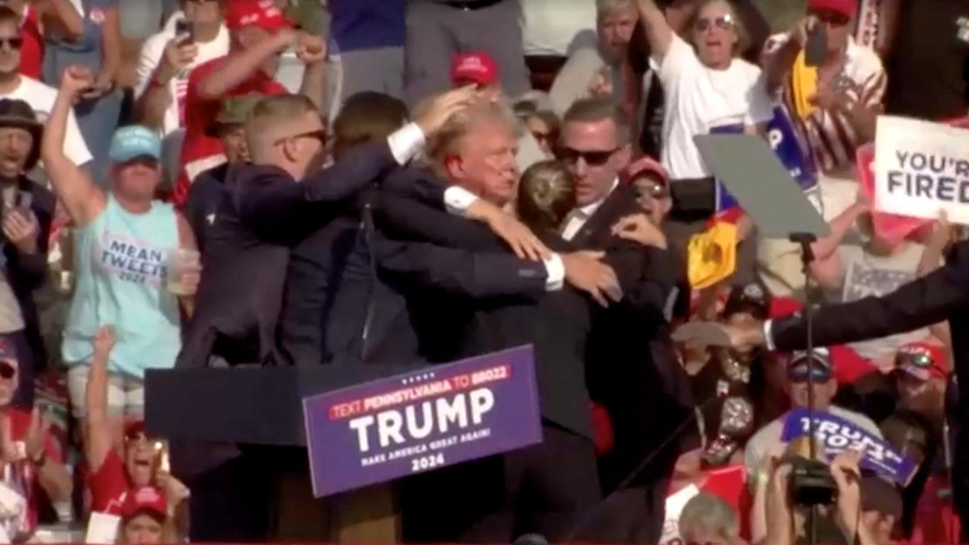 Republican presidential candidate and former U.S. President Donald Trump is assisted by security personnel after gunfire rang out during a campaign rally at the Butler Farm Show in Butler, Pennsylvania, U.S., July 13, 2024, in this screen grab taken from a video. ABC/US Network Pool/ Handout via REUTERS ATTENTION EDITORS - THIS PICTURE WAS PROVIDED BY A THIRD PARTY. NO RESALES. NO ARCHIVES. MANDATORY CREDIT. Photo: ABC/US Network Pool/REUTERS