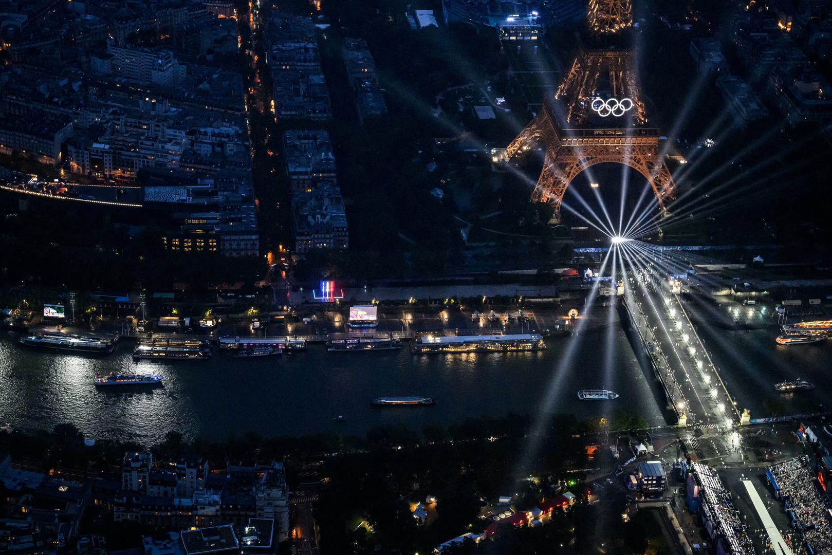 Paris 2024 Olympics - Opening Ceremony - Paris, France - July 26, 2024. An aerial view of delegation boats navigating down the Seine river near the illuminated Eiffel Tower, during the opening ceremony of the Paris 2024 Olympic Games.     LIONEL BONAVENTURE/Pool via REUTERS Photo: LIONEL BONAVENTURE/REUTERS