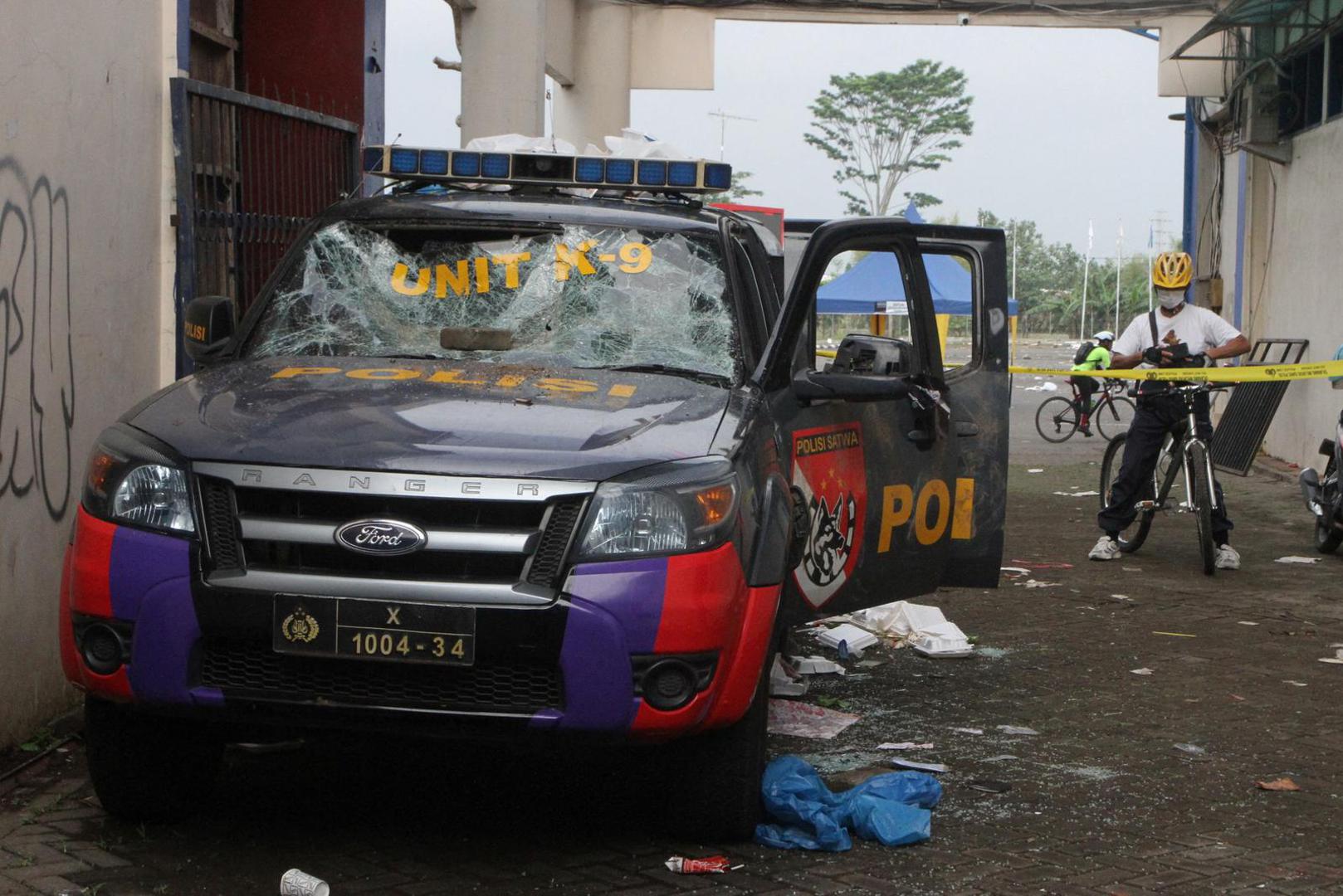 A person stands next to a damaged car following a riot after the league BRI Liga 1 football match between Arema vs Persebaya at Kanjuruhan Stadium, Malang, East Java province, Indonesia, October 2, 2022, in this photo taken by Antara Foto. Antara Foto/Ari Bowo Sucipto/ via REUTERS. ATTENTION EDITORS - THIS IMAGE HAS BEEN SUPPLIED BY A THIRD PARTY. MANDATORY CREDIT. INDONESIA OUT. NO COMMERCIAL OR EDITORIAL SALES IN INDONESIA. Photo: ANTARA FOTO/REUTERS