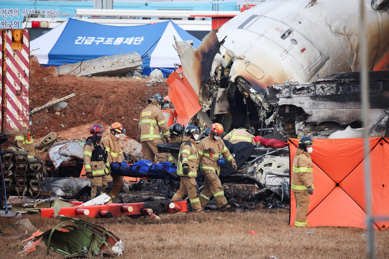 Firefighters carry the body of a passenger from the wreckage of an aircraft that crashed after it went off the runway at Muan International Airport, in Muan, South Korea, December 29, 2024. REUTERS/Kim Hong-Ji Photo: KIM HONG-JI/REUTERS