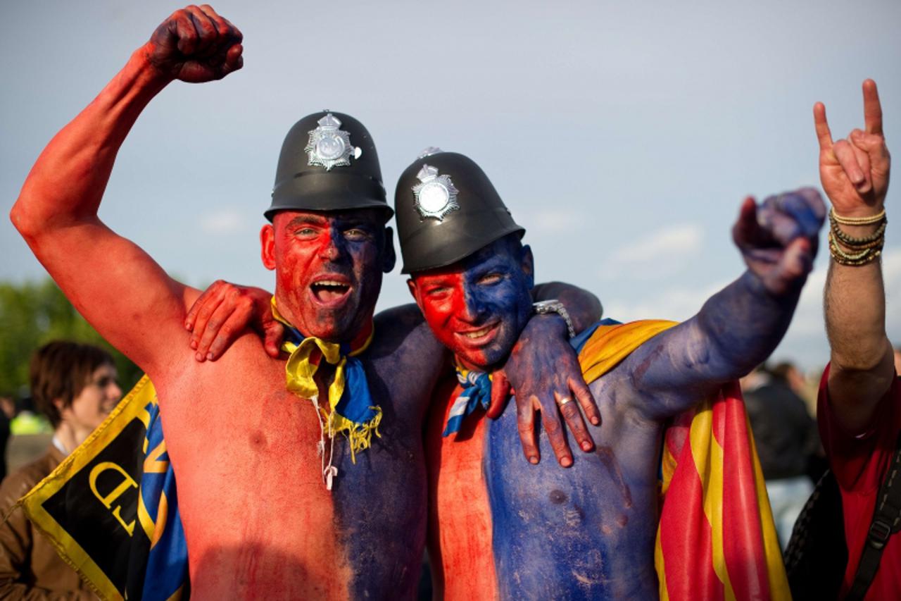 'Football supporters pose outside Wembley Stadium on May 28, 2011 in London before the UEFA Champions League final football match FC Barcelona vs. Manchester United.  AFP PHOTO/Leon Neal'