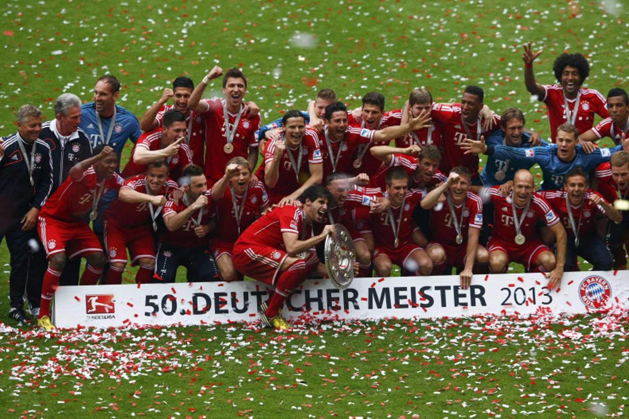 'Bayern Munich\'s players pose with the trophy after their German first division Bundesliga soccer match against Augsburg in Munich, May 11, 2013. Bayern held their 23rd German league title on Saturda