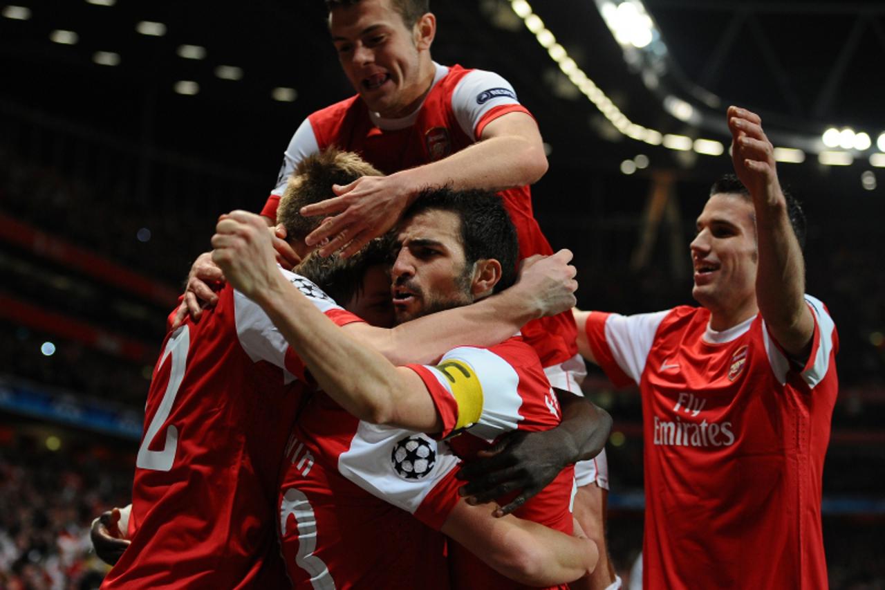 \'Arsenal\'s players celebrate after scoring a goal during their Champions League round of 16, 1st leg football match Arsenal vs FC Barcelona on February 16, 2011 at the Emirates stadium in London. AF