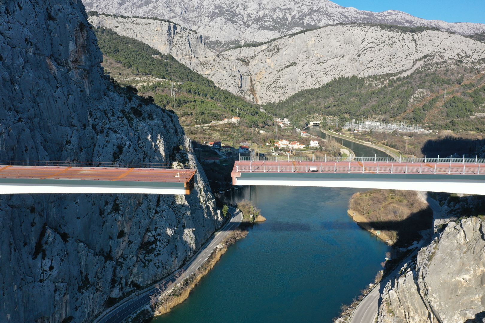 09.02.2023., Omis - Spajanje mosta iznad rijeke Cetine kod Omisa na 70 metara nadmorske visine koji je dio omiske zaobilaznice. Omiska obilaznica jedan od najvecih infrastrukturnih objekata u Splitsko-dalmatinskoj zupaniji, a zaobilaznicu ukljucuju dva tunela i most preko Cetine, tunel Komorjak dug vise od 600 metara, a Omis vise od 500 metara, dok ce most biti u duzini od 216 metara. Investitor je tvrtka Hrvatske ceste, koja je za prvu fazu brze ceste Split - Omis izdvojila 174,5 milijuna kuna, a s radovima se pocelo u rujnu 2019.  Photo: Matko Begovic/PIXSELL