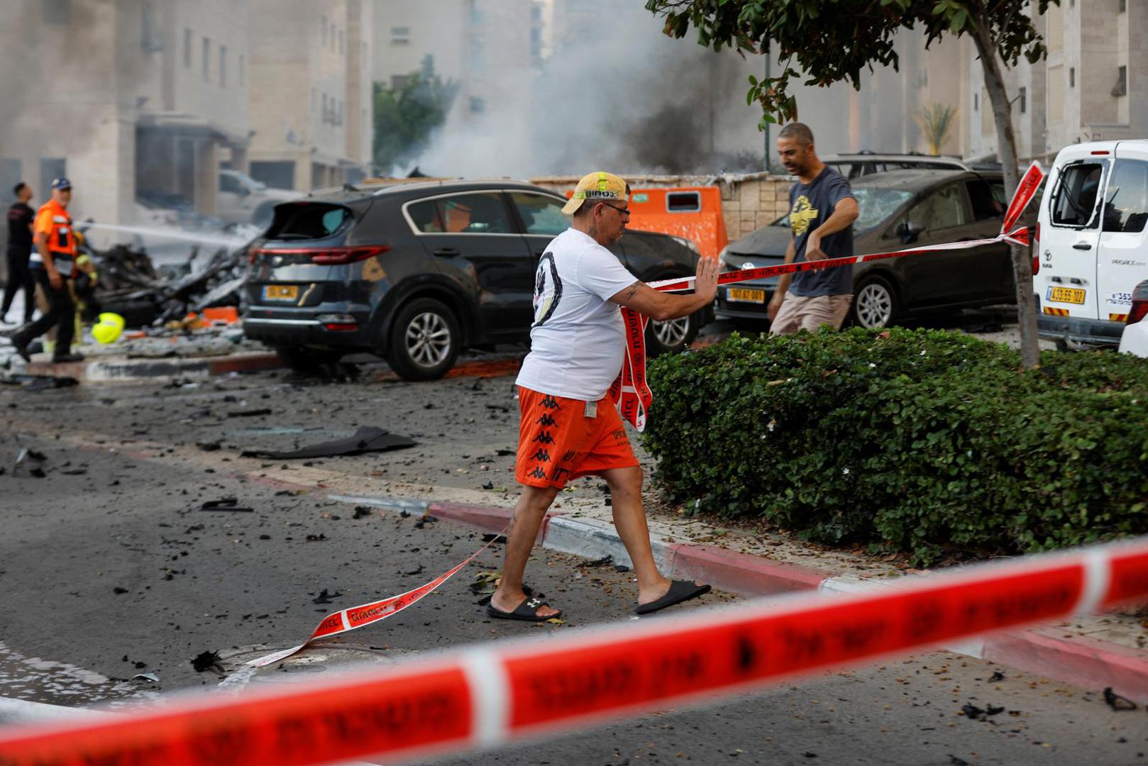 A man puts up security tape, after rockets were launched from the Gaza Strip, in Ashkelon, Israel October 7, 2023. REUTERS/Amir Cohen Photo: AMIR COHEN/REUTERS