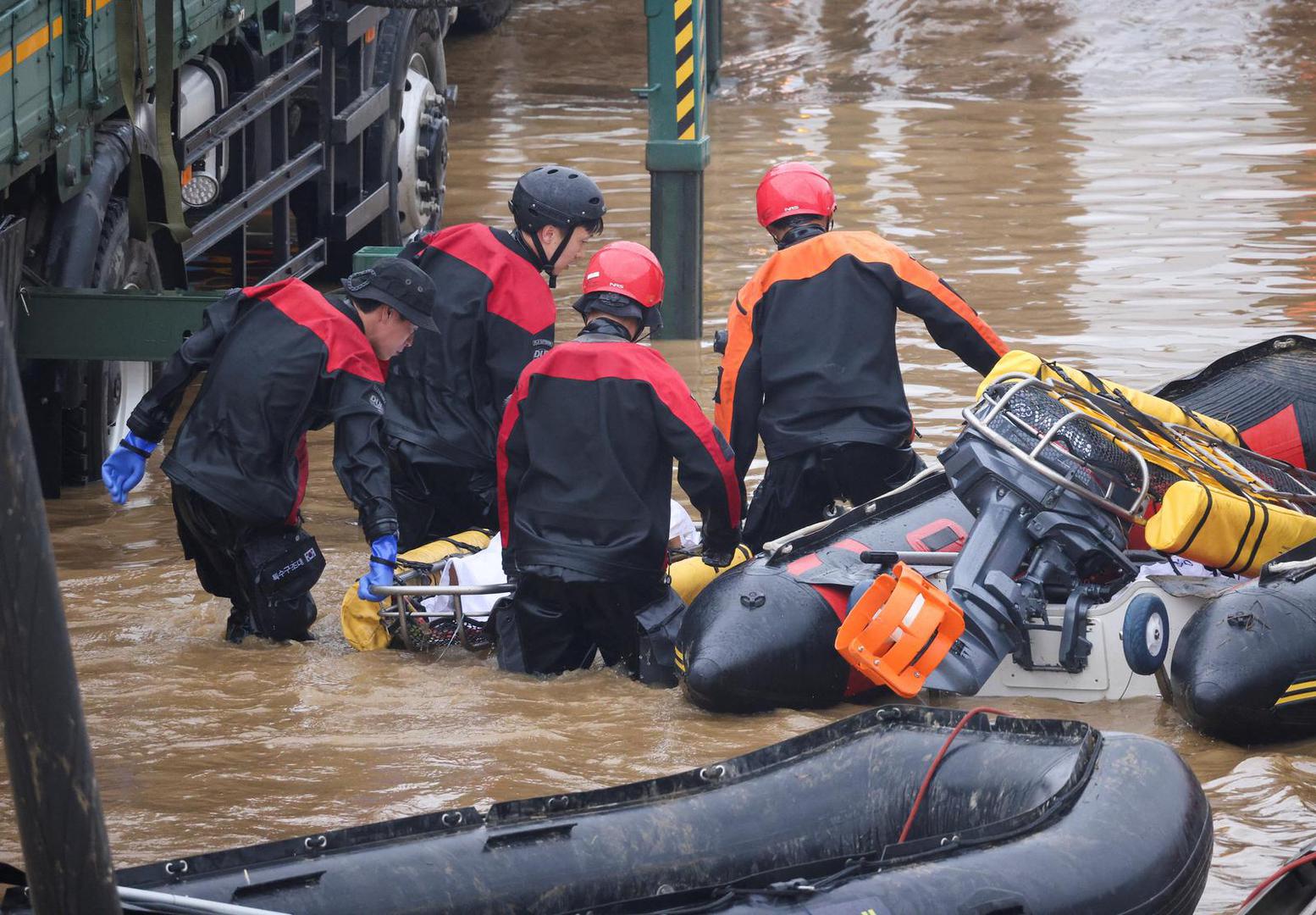 Rescue workers carry the body of a victim recovered during a search and rescue operation near an underpass that has been submerged by a flooded river caused by torrential rain in Cheongju, South Korea, July 16, 2023.   REUTERS/Kim Hong-ji Photo: KIM HONG-JI/REUTERS