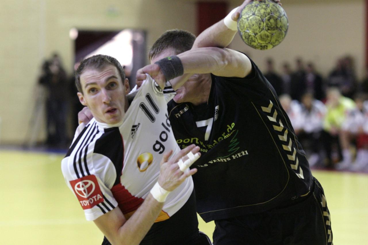 \'Germany\'s Holger Glandorf (L) fights with Latvia\'s Aivis Jurdzs during their men\'s handball European Championship qualification game in Dobele October 31, 2010. REUTERS/Ints Kalnins (LATVIA - Tag