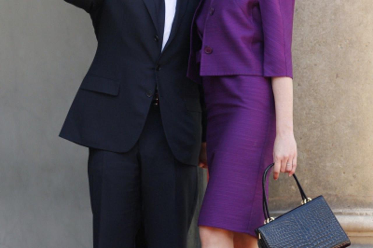 'French President Nicolas Sarkozy and his wife Carla Bruni Sarkozy arrive at the Elysee palace after the annual Bastille Day military parade in Paris July 14, 2008. REUTERS/Benoit Tessier (FRANCE)'