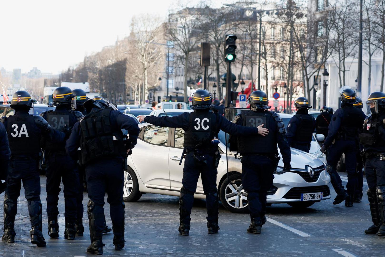 Police officers evacuate the Champs-Elysees avenue as cars parade during their "Convoi de la liberte" (The Freedom Convoy), a vehicular convoy to protest coronavirus disease (COVID-19) vaccine and restrictions in Paris, France, February 12, 2022. REUTERS/Benoit Tessier Photo: BENOIT TESSIER/REUTERS