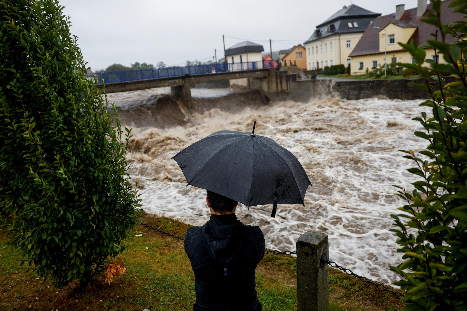 A man holds an umbrella as he looks at floodwaters following heavy rainfalls in Mikulovice, Czech Republic, September 14, 2024. REUTERS/David W Cerny Photo: DAVID W CERNY/REUTERS