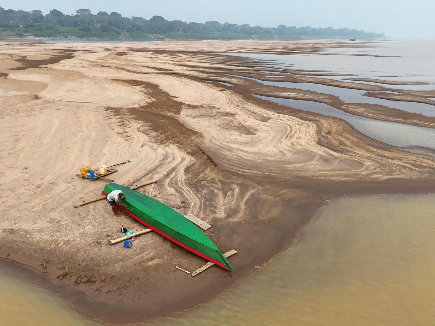 A drone view shows Reis Santo Vieira da Silva as a river dweller builds a canoe on the sandbanks of Madeira River during the worst drought of the river in history, in Humaita, Amazonas state, Brazil, September 7, 2024. REUTERS/Bruno Kelly Photo: BRUNO KELLY/REUTERS