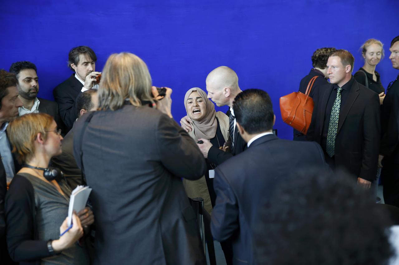 A bodyguard holds an undentified female journalist (C) as she shouts abuse at Egypt's President Abdel Fattah al-Sisi during a joint news conference with German Chancellor Angela Merkel at the Chancellery in Berlin, Germany June 3, 2015.         REUTERS/Fa