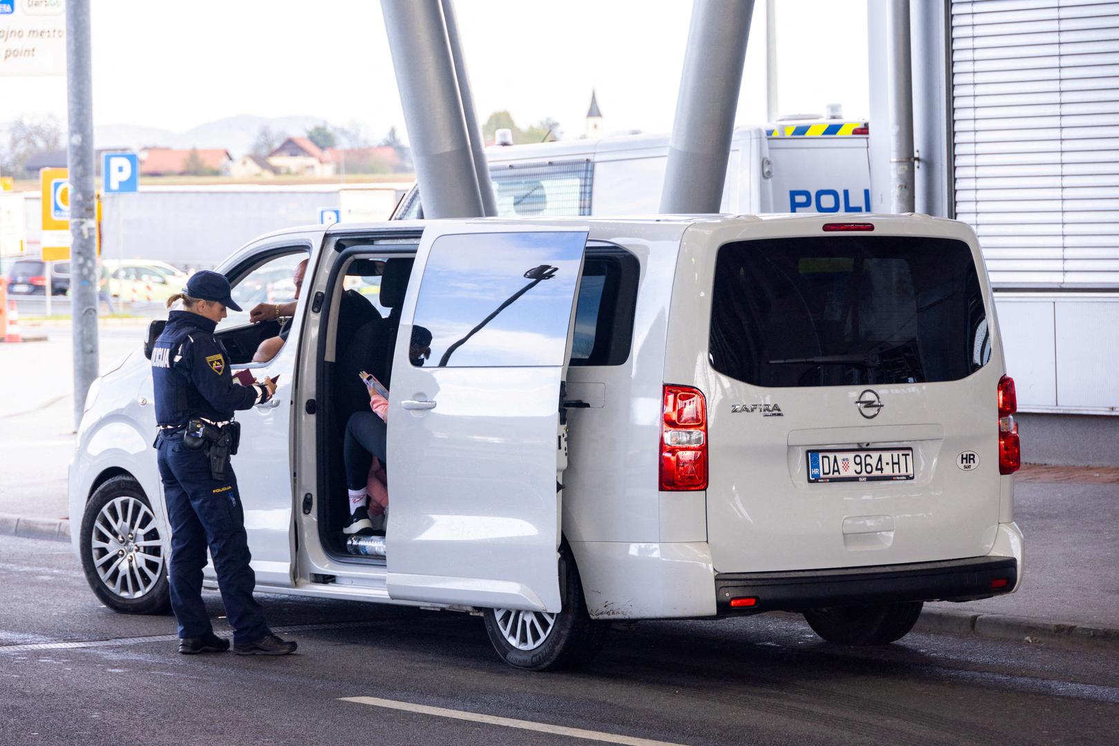 A Police officer inspects documents at the border crossing in Obrezje, Slovenia, October 21, 2023. REUTERS/Antonio Bronic Photo: Antonio Bronic/REUTERS