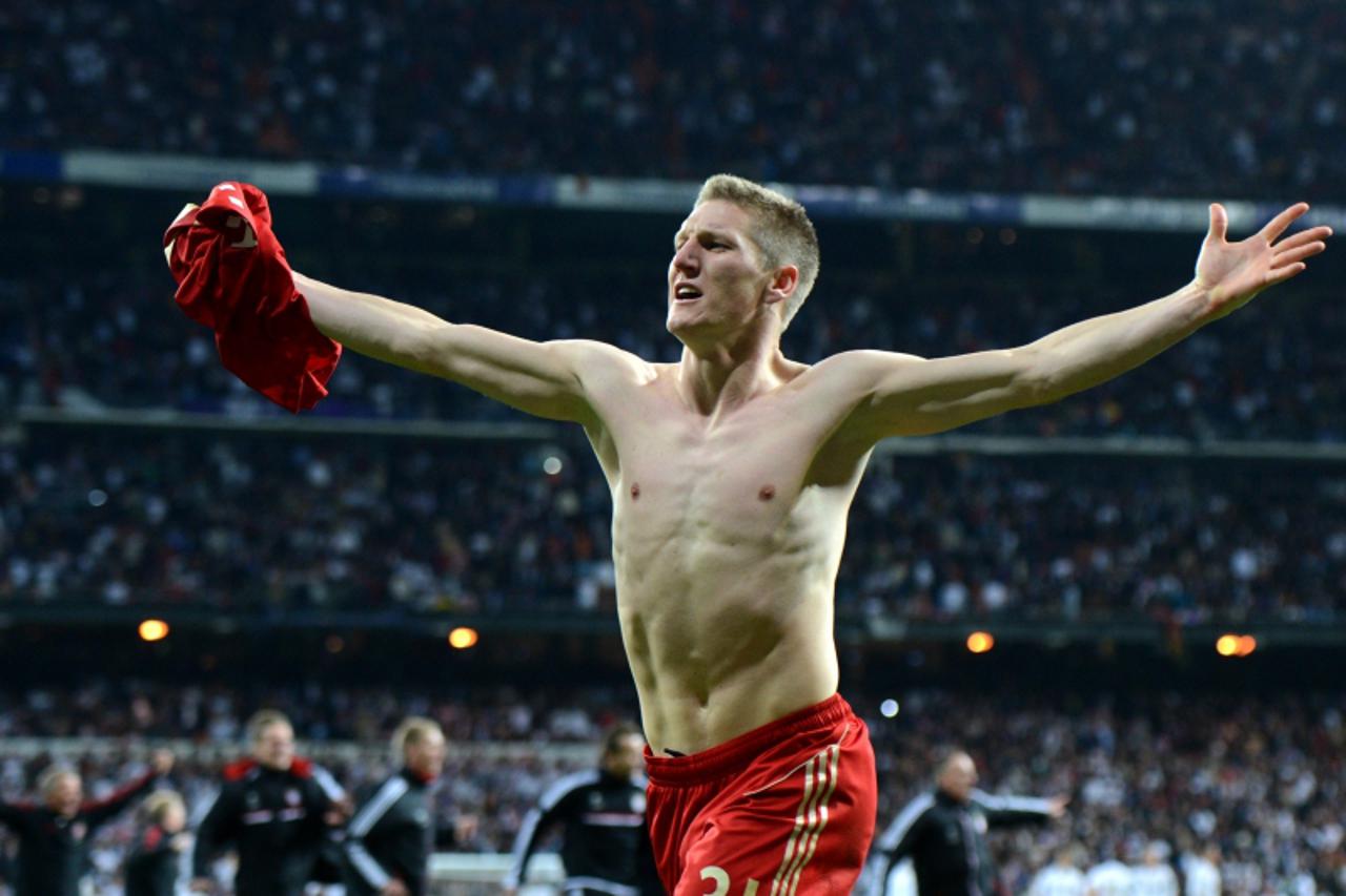 'Bayern Munich\'s midfielder Bastian Schweinsteiger celebrates after scoring the winning penalty after the UEFA Champions League second leg semi-final football match Real Madrid against Bayern Munich 