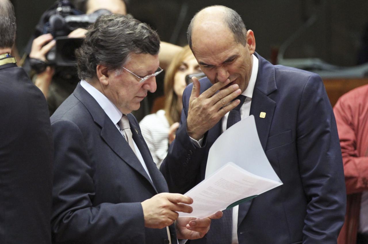 'European Commission President Jose Manuel Barroso and Slovenia's Prime Minister Janez Jansa (R) look at a document during a European Union leaders summit in Brussels June 29, 2012. Euro zone leaders