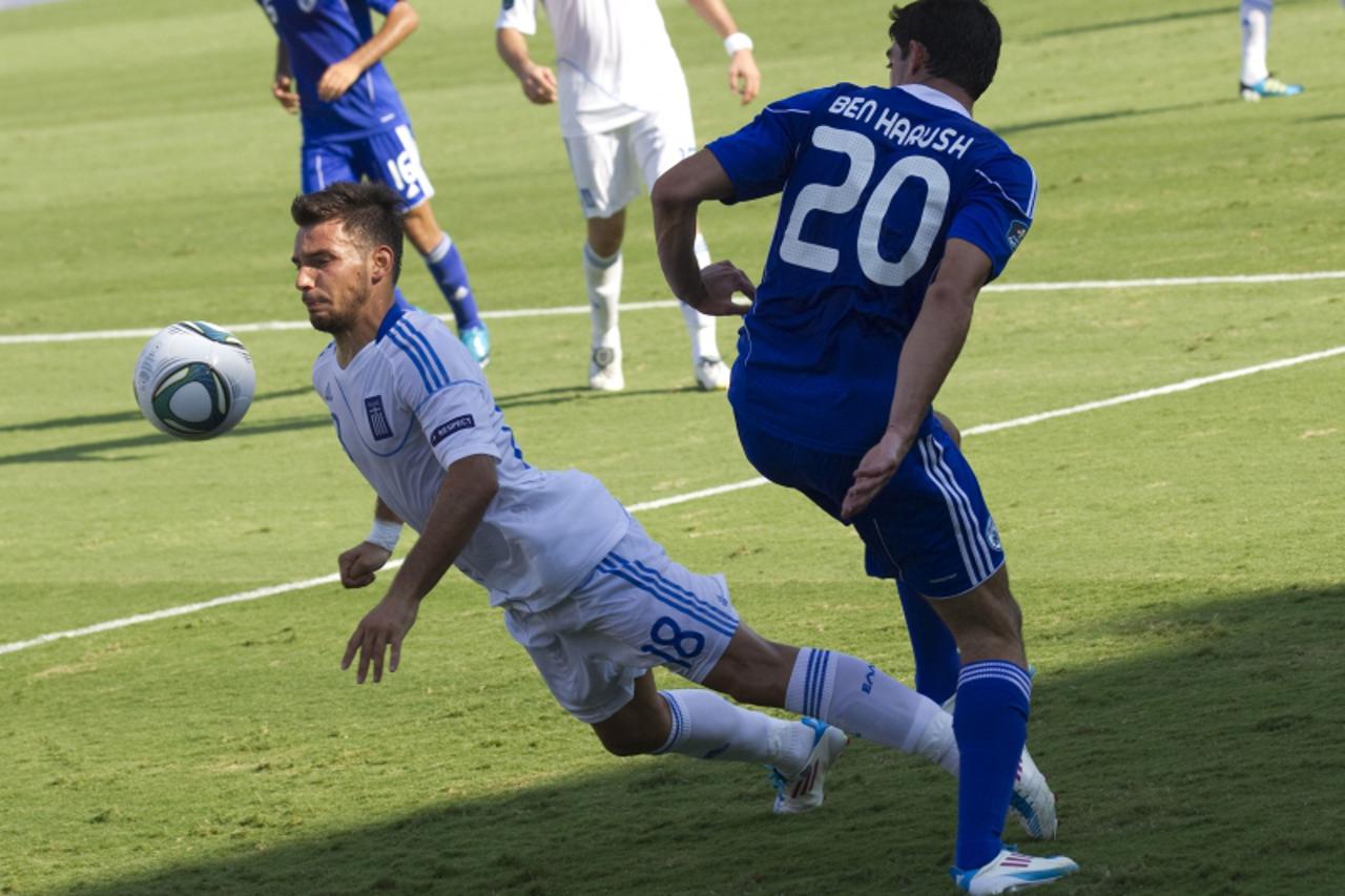 'Greek\'s midfielder Sotiris Ninis (L) vies for the ball with Israels Omri Ben Harush  (R) at the Bloomfield Staduim in Tel Aviv on September 02, 2011 during their Euro 2012 qualifying group F footba