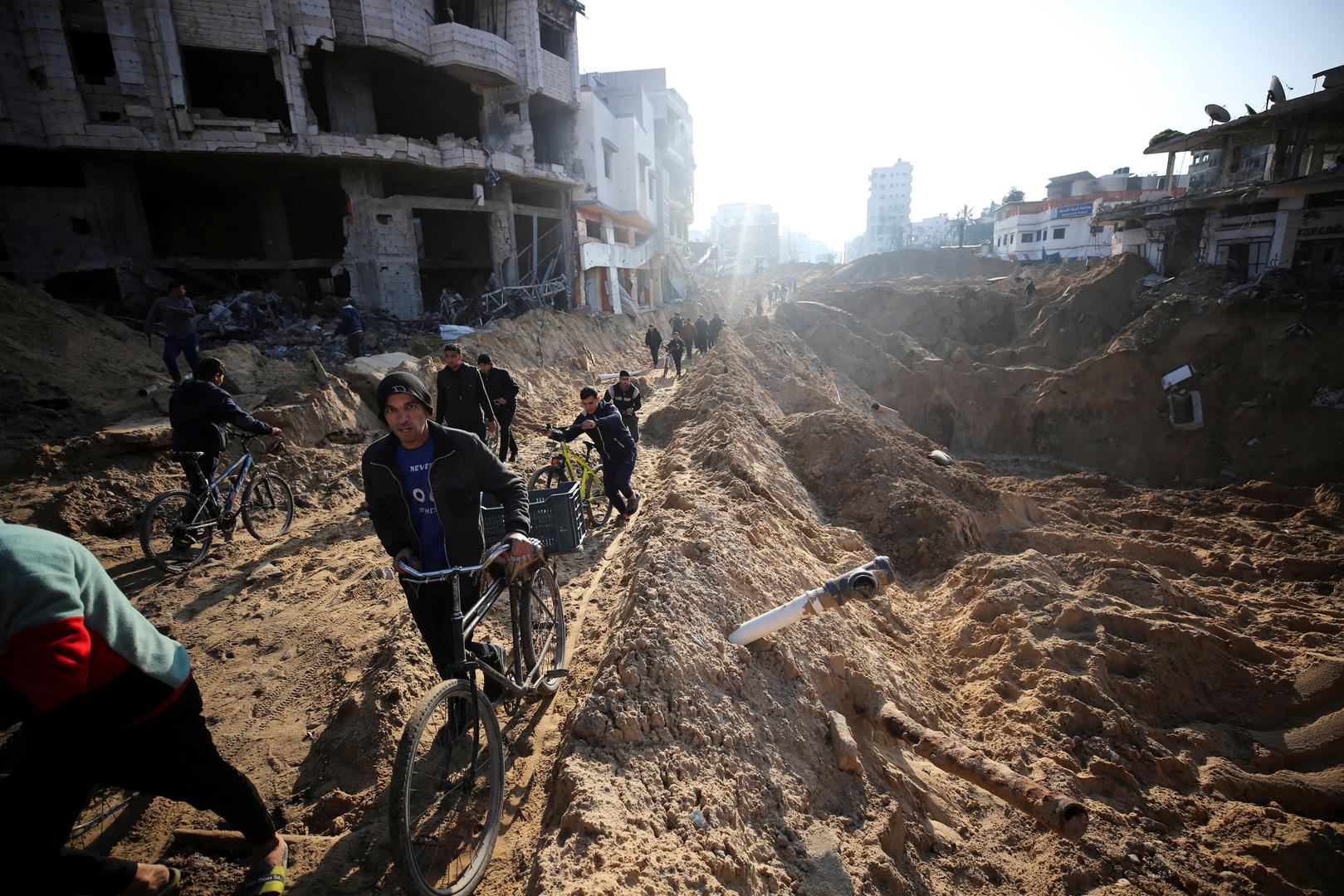 Palestinians walk near damaged buildings following an Israeli ground operation, amid the ongoing conflict between Israel and Hamas, in Gaza City, February 10, 2024. REUTERS/Stringer Photo: STRINGER/REUTERS