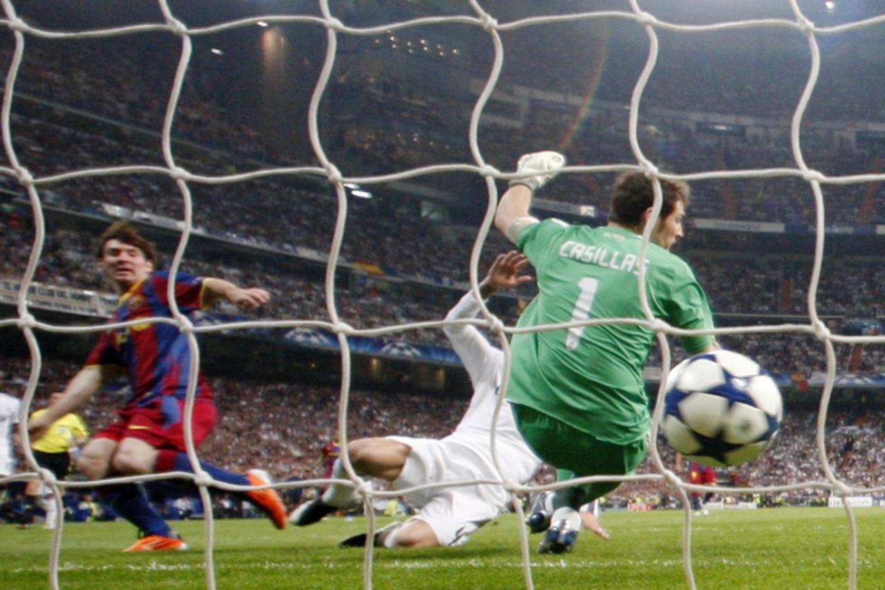 'Barcelona\'s player Lionel Messi scores against Real Madrid\'s goalkeeper Iker Casillas during their Champions League semi-final first leg soccer match at Santiago Bernabeu stadium in Madrid April 27