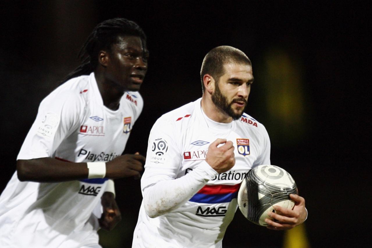 'Olympique Lyon\'s Lisandro Lopez (R) celebrates after scoring during their French Ligue 1 soccer match against Lorient at the Moustoir stadium in Lorient, western France, January 20, 2010. REUTERS/St