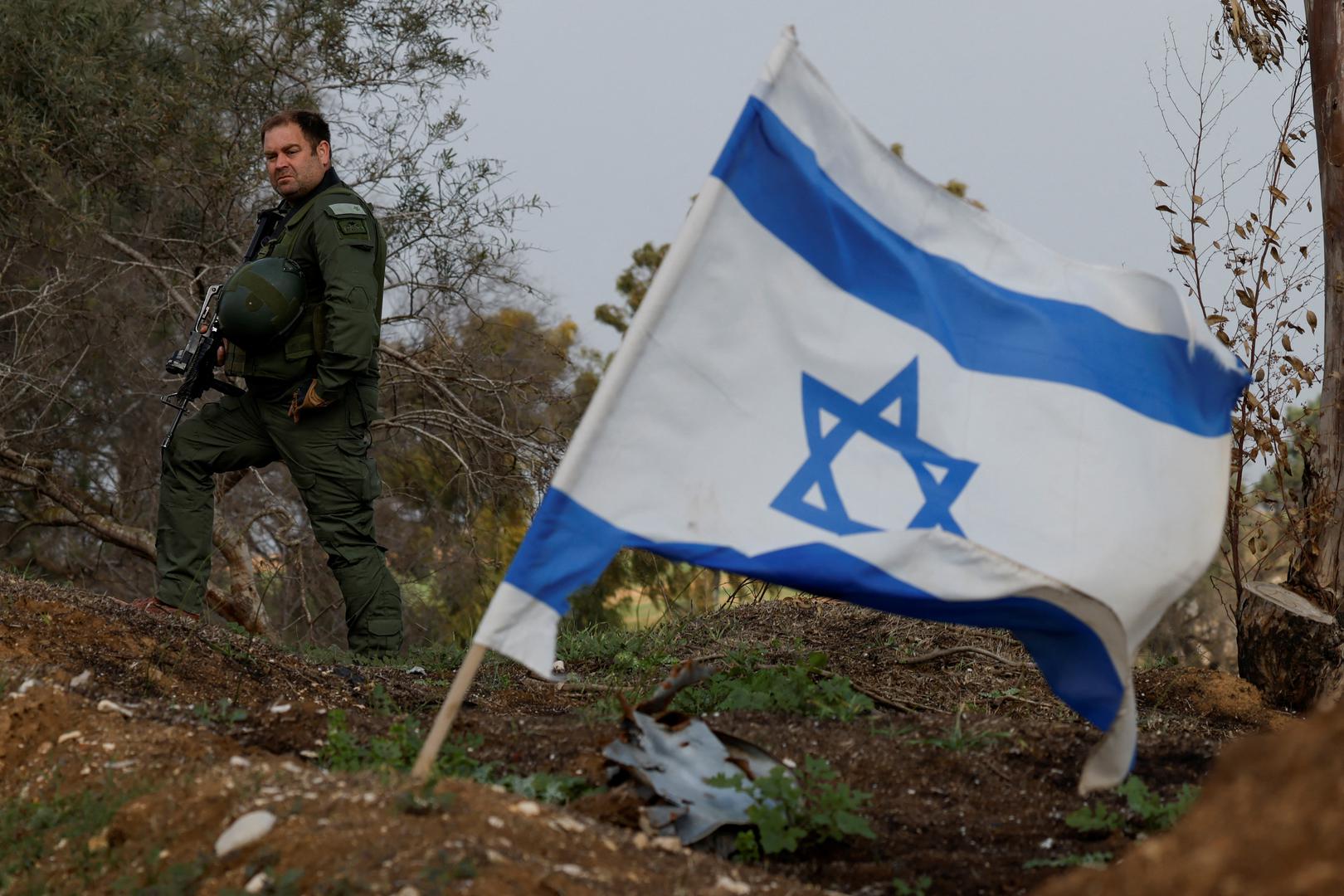 An Israeli soldier stands next to an Israeli flag, as people attend a protest to call for the release of Israeli hostages in Gaza and to mark 100 days since the October 7 attack by Palestinian Islamist group Hamas, amid the ongoing conflict between Israel and Hamas in Beeri, Israel, January 14, 2024. REUTERS/Tyrone Siu Photo: TYRONE SIU/REUTERS