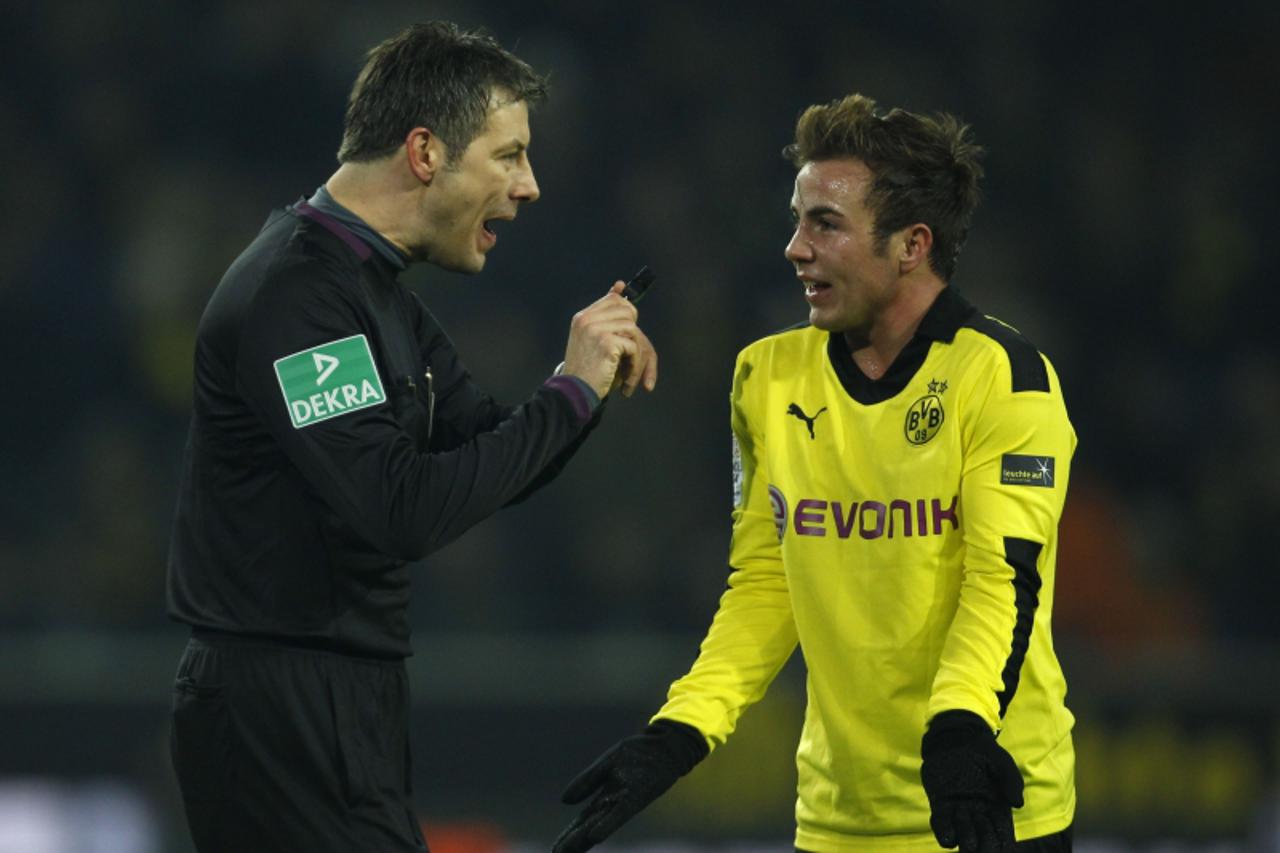 'Referee Wolfgang Stark (L) reacts to Borussia Dortmund\'s Mario Goetze during the German first division Bundesliga soccer match against Wolfsburg in Dortmund December 8, 2012. REUTERS/Ina Fassbender 