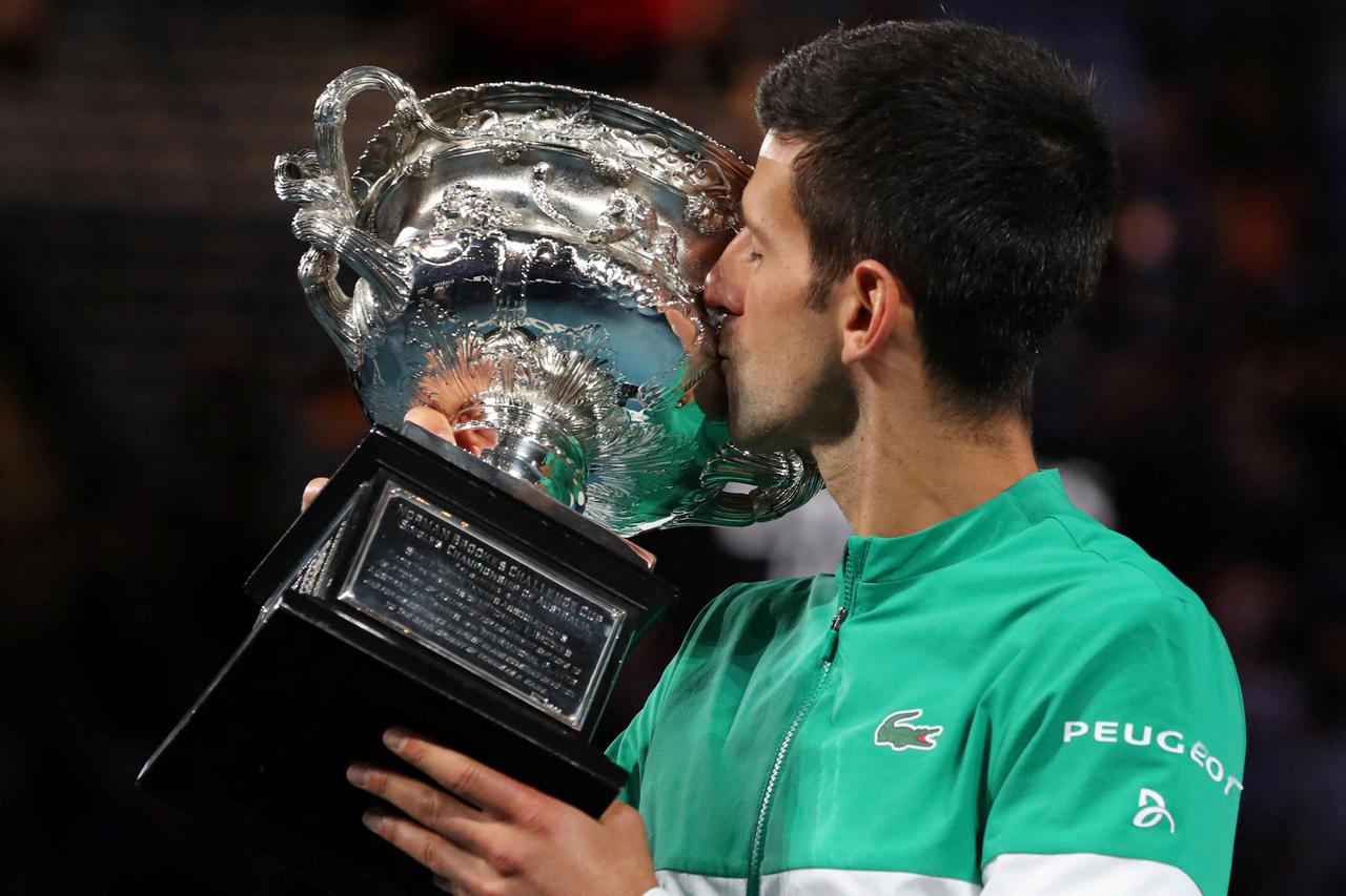 FILE PHOTO: Serbia's Novak Djokovic celebrates with the trophy after winning his ninth Australian Open title