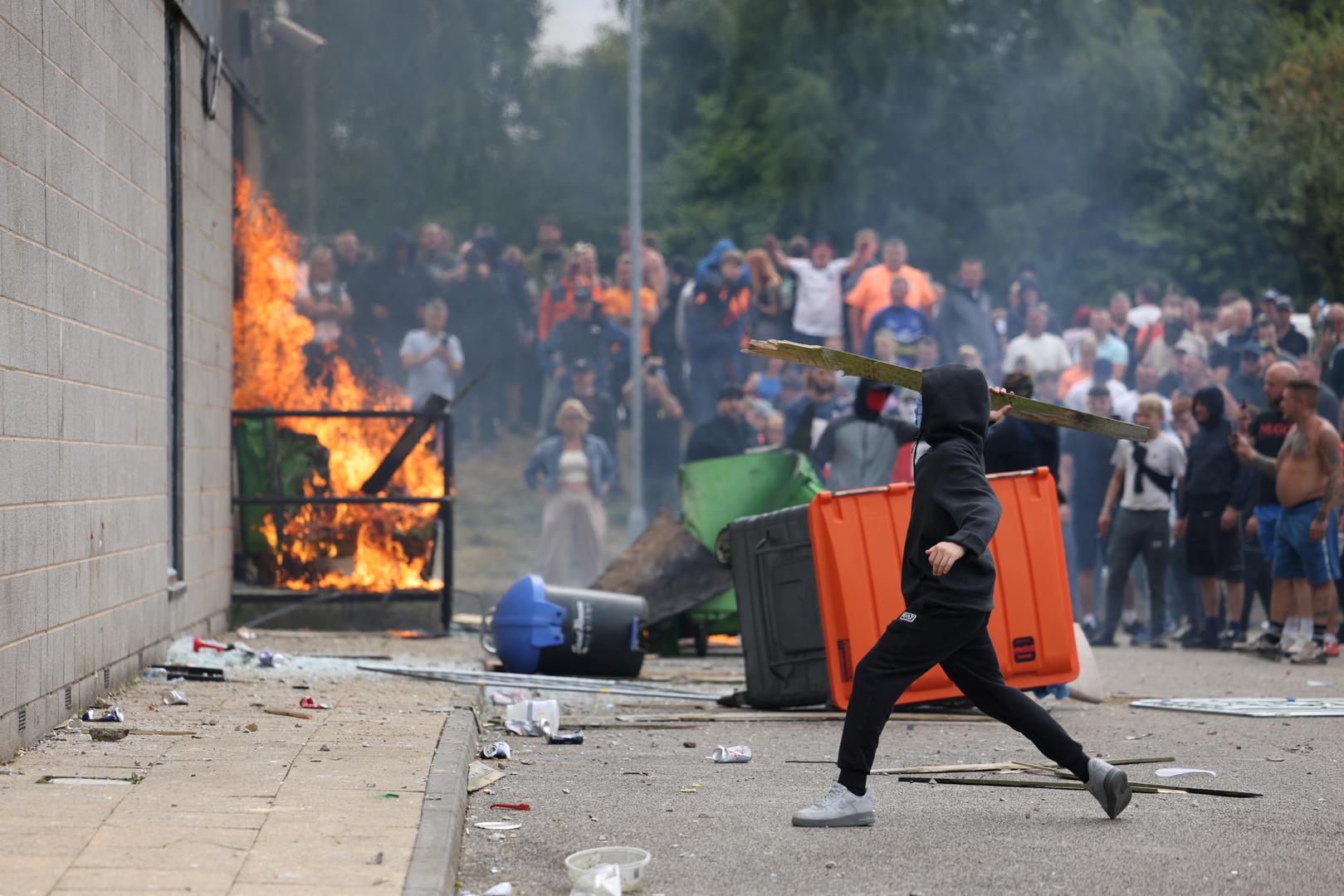 A protestor throws an object towards a hotel in Rotherham, Britain, August 4, 2024. REUTERS/Stringer Photo: Stringer/REUTERS