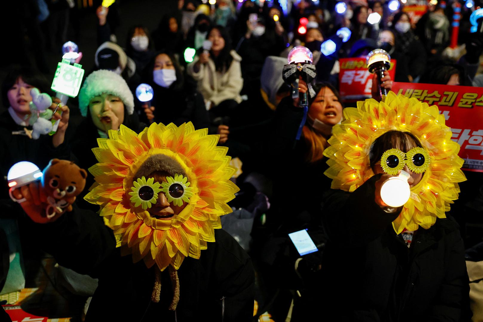 People wearing flower headwear and glasses attend a rally calling for the impeachment of South Korean President Yoon Suk Yeol, who declared martial law, which was reversed hours later, near the National Assembly in Seoul, South Korea, December 8, 2024. REUTERS/Kim Kyung-Hoon Photo: KIM KYUNG-HOON/REUTERS