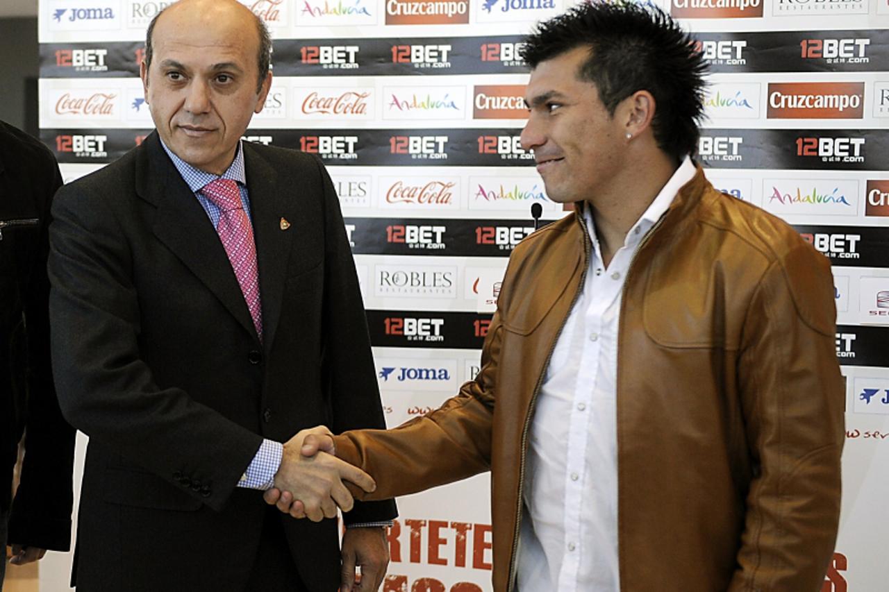 \'Sevila FC\'s new signing Chilean midfielder Gary Medel (R) shakes hands with his new club\'s president Jose Maria del Nido during his presentation to the media on January 31, 2011 in Sevilla.      A