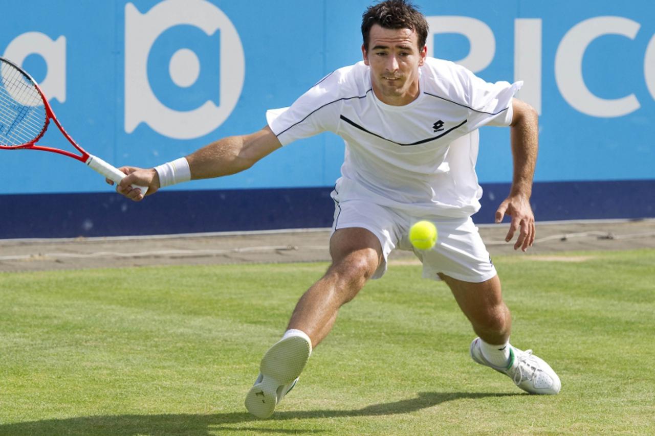 'Ivan Dodig of Croatia returns a shot to Dmitry Tursunov of Russia during their men\'s final match at the UNICEF Open tennis tournament in Den Bosch June 18, 2011. REUTERS/Paul Vreeker/United Photos (