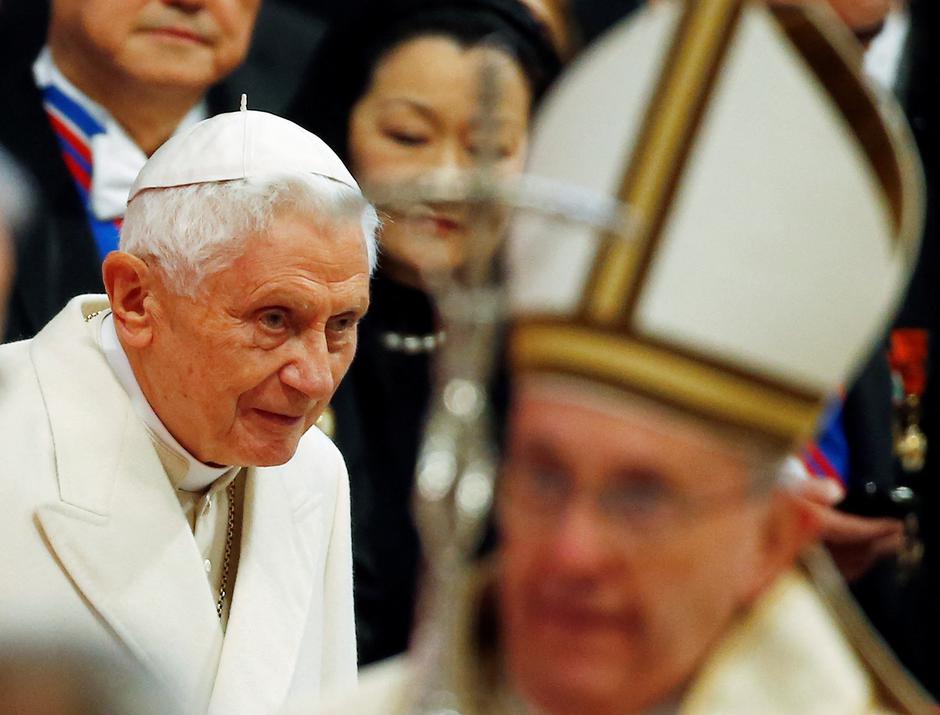 FILE PHOTO: Emeritus Pope Benedict XVI looks on as Pope Francis arrives to lead a mass to create 20 new cardinals during a ceremony in St. Peter's Basilica at the Vatican