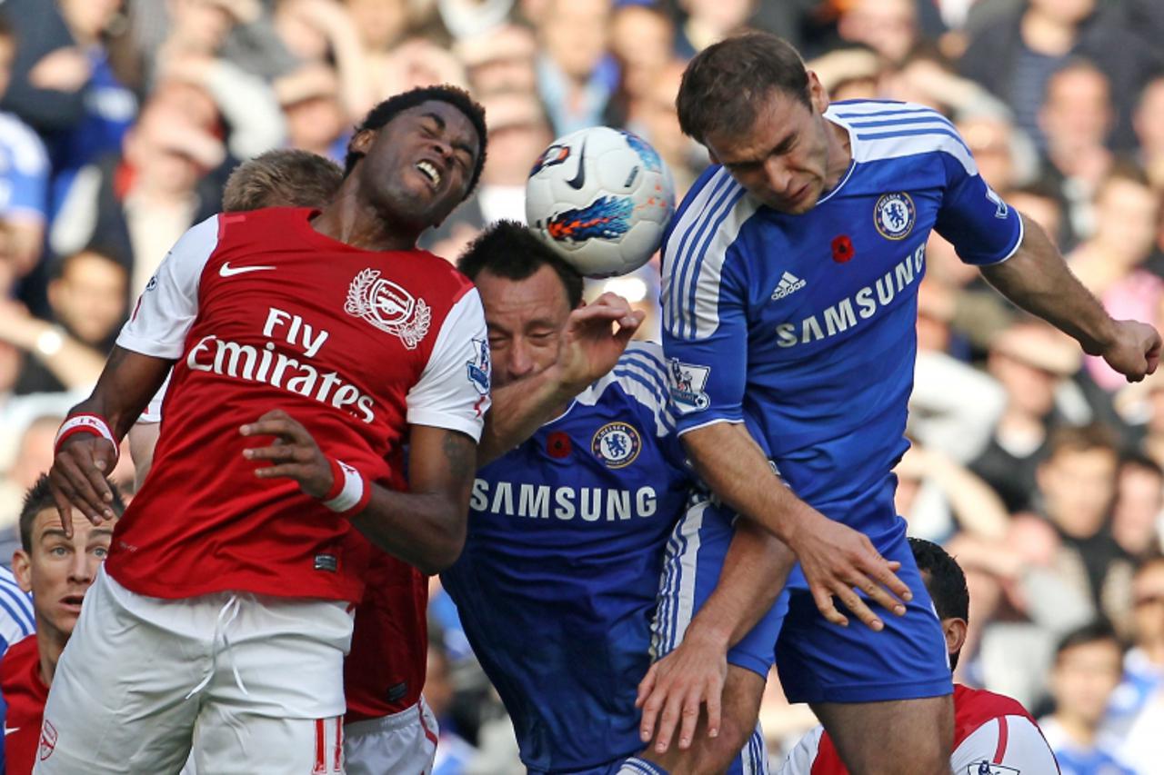 'Arsenal\'s Cameroonian midfielder Alex Song (L) vies with Chelsea\'s English defender John Terry (2nd L) and Serbian defender Branislav Ivanovic (R) during the English Premier League football match b