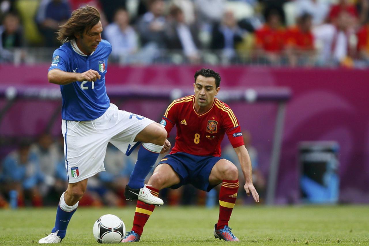 'Italy's Andrea Pirlo (L) and Spain's Xavi Hernandez (R) challenge for the ball during their Group C Euro 2012 soccer match at the PGE Arena in Gdansk, June 10, 2012.         REUTERS/Kai Pfaffenbach