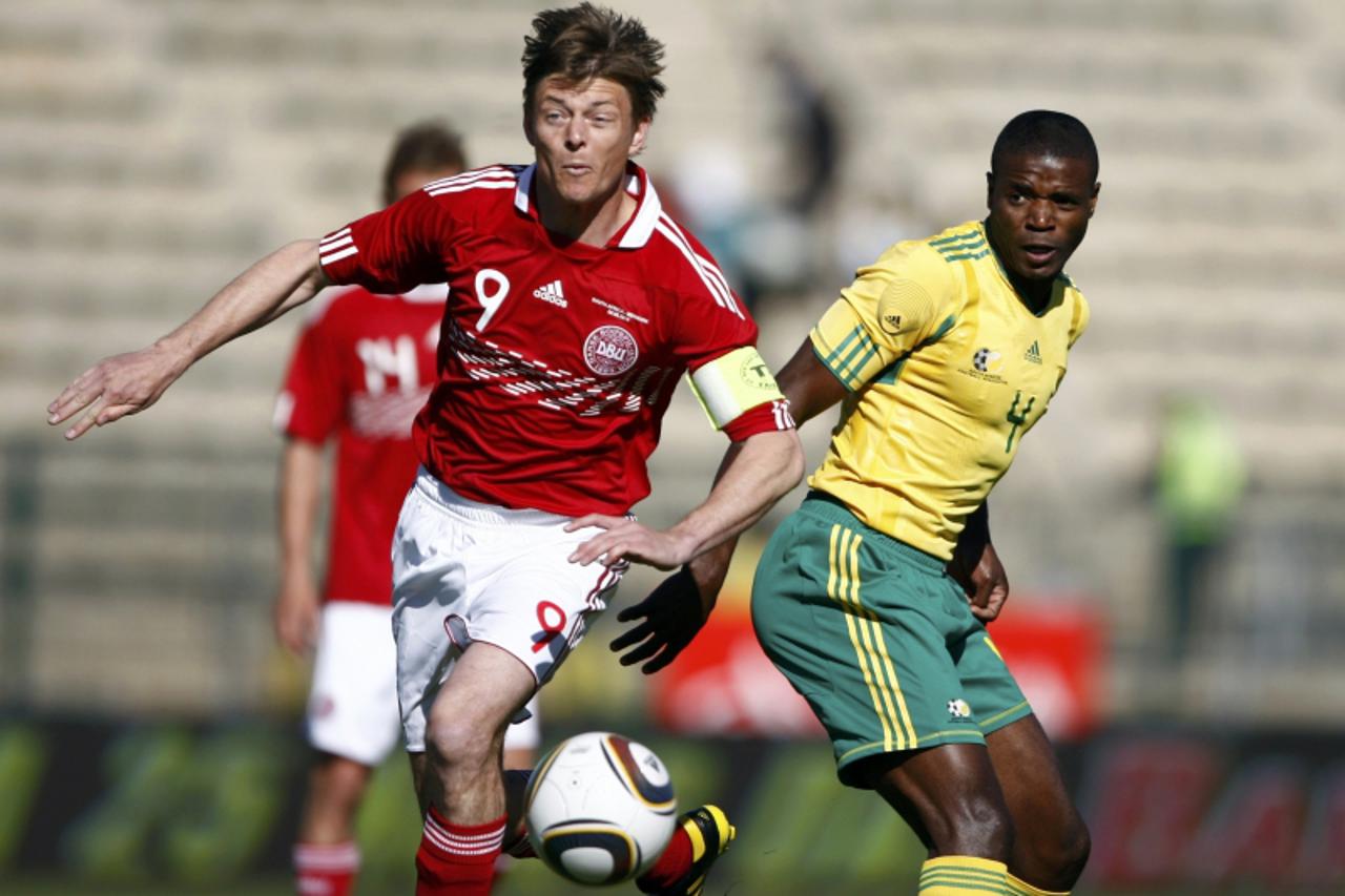 'South Africa\'s Aaron Mokoena (R) challenges Denmark\'s Jon Dahl Tomasson (L) during their international friendly soccer match at the Super Stadium in Pretoria June 5, 2010. The 2010 FIFA Soccer Worl