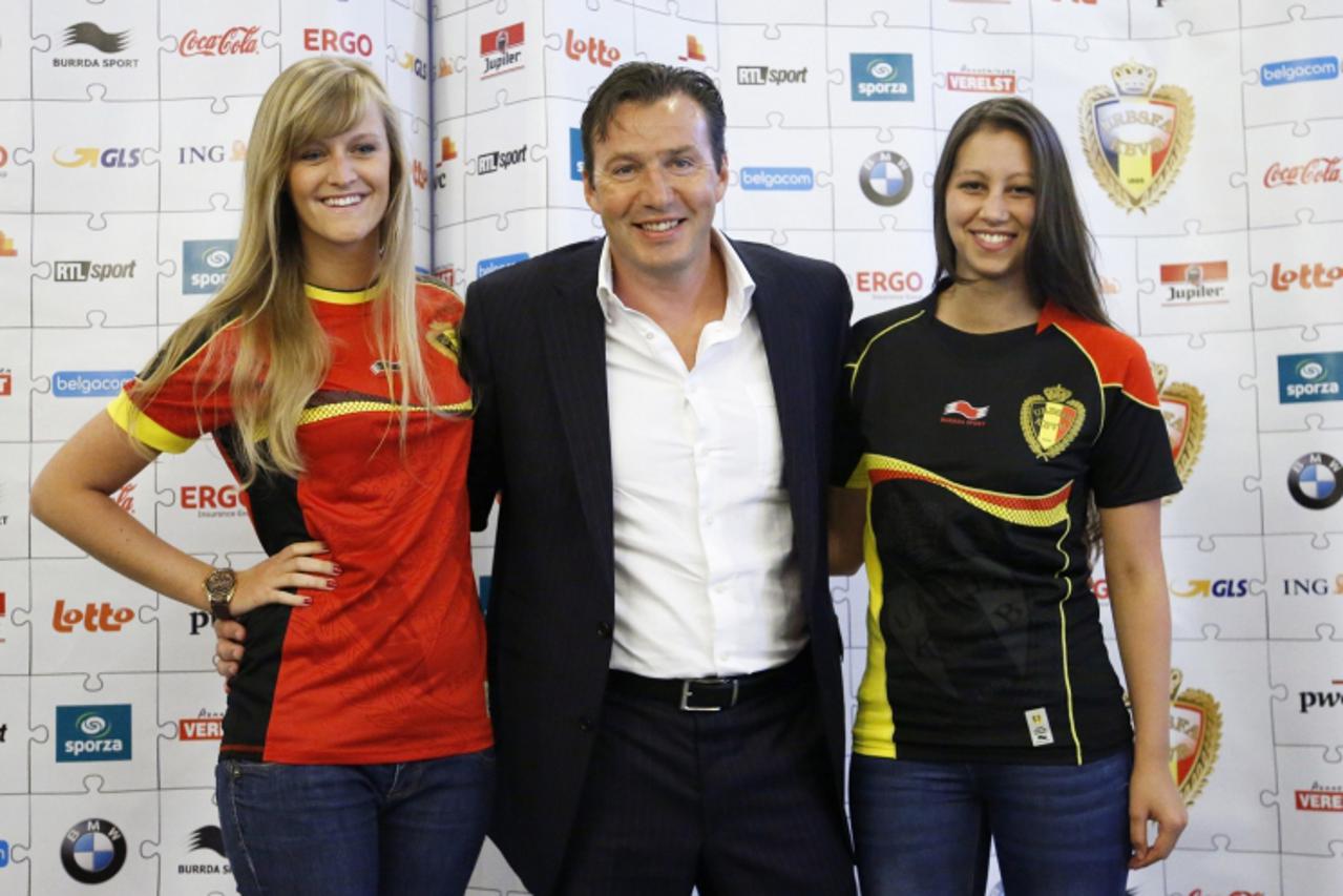 'Belgium\'s soccer team coach Marc Wilmots (C) poses with models wearing the new team jerseys during a news conference in Brussels August 9, 2012. Belgium will play a friendly soccer match against Net