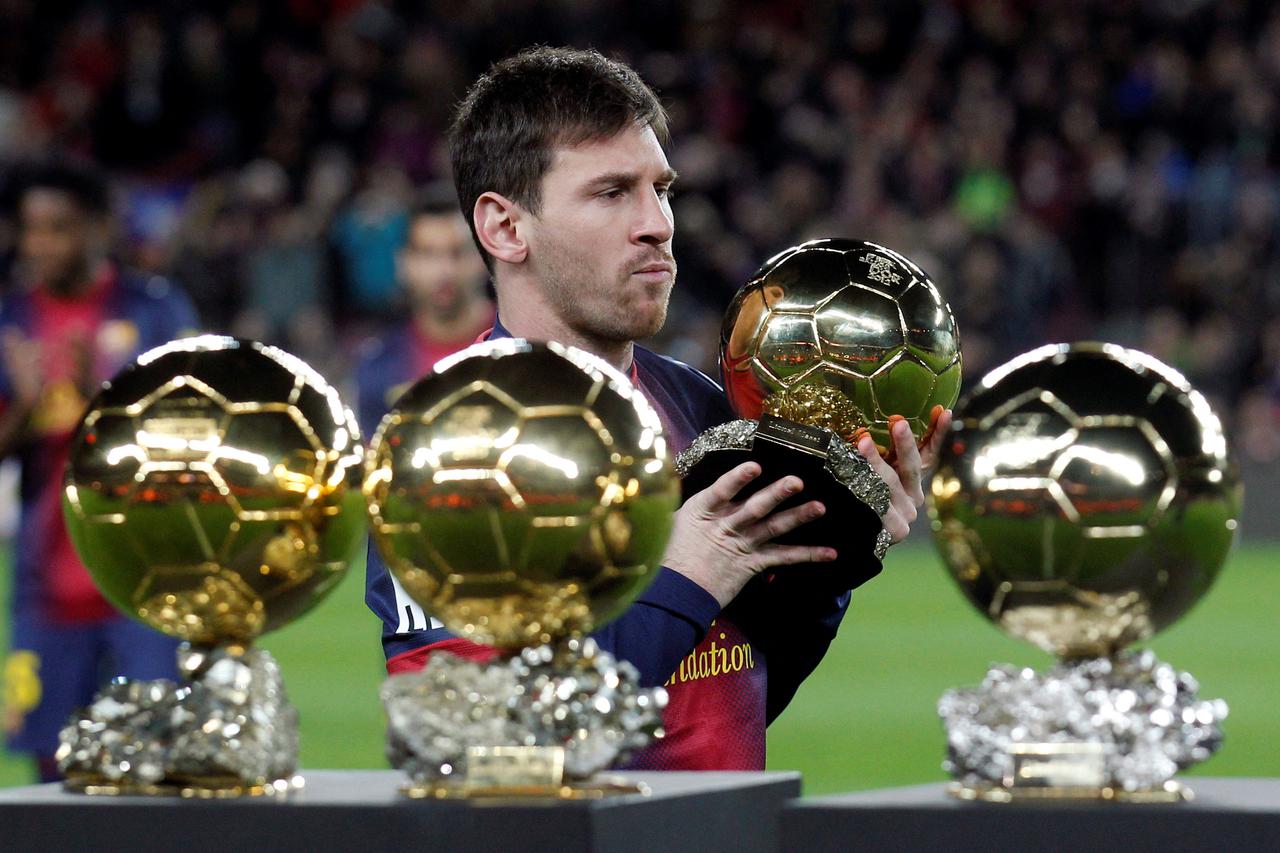 FILE PHOTO: Barcelona's Messi poses with his four Ballon d'Or trophies in Barcelona